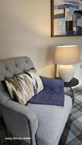 sala de estar con sofá, almohada y lámpara. en Bala Holiday Suites, en Bala