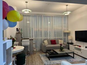 ein Wohnzimmer mit einem Sofa, einem Tisch und einem TV in der Unterkunft Apartment in Al Sufouh 1st - Comfortable Home with 5 iconic views in Dubai