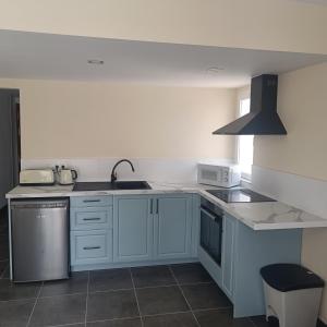 a kitchen with white cabinets and a sink at Duquesa Harbour Club Aparthotel in Manilva