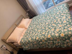 Ban Bang YaiGc rooms的床上有鲜花铺的毯子,有窗户 更多10张照片