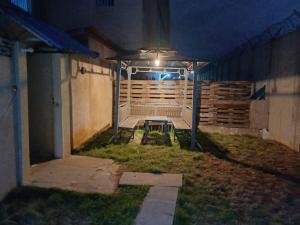 a patio at night with a bench in the grass at Sweet and cozy in Cotonou