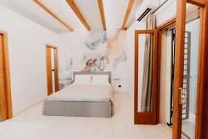 1 dormitorio con 1 cama y una pintura en la pared en Dimora L'Etual en Bari