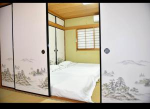 a bedroom with a bed and two glass doors at Peace & Harmony 1 in Nagoya