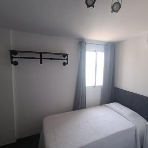 a bedroom with a white bed and a window at Duquesa Harbour Club Aparthotel in Manilva