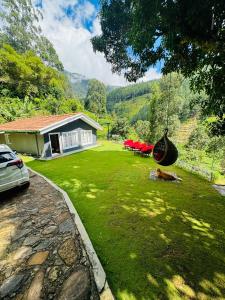 a yard with a dog laying in the grass at Jayawardane’s Bungalow in Mandaramnuwara in Mandaran Newara