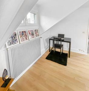 Cette chambre mansardée comprend une table et un bureau. dans l'établissement Coin Cosy à Verneuil, à Verneuil-sur-Seine