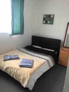 ein Schlafzimmer mit einem Bett mit zwei Handtüchern darauf in der Unterkunft 9 bed house with garden & parking in Iford