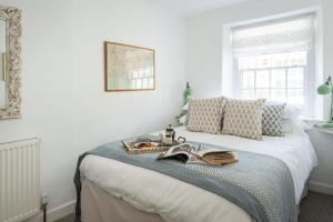 Un dormitorio con una cama con una bandeja de libros. en 21 Island Street en Salcombe