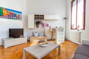 een woonkamer met een tafel en een televisie bij Toniolo venice rooms in Mestre