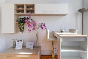 een keuken met een bureau en een vaas met paarse bloemen bij Toniolo venice rooms in Mestre