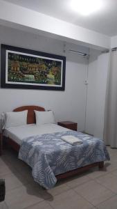 sypialnia z łóżkiem i zdjęciem na ścianie w obiekcie Hospedaje Moralillos w mieście Yurimaguas