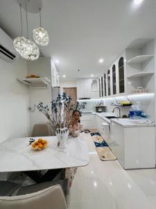 a white kitchen with a vase of flowers on a counter at Resort Ori q9 3, giường, 2pn+ 2wc in Long Bình