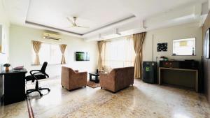 salon z 2 krzesłami i biurkiem w obiekcie BluO Lake View NewTown - LUXE Stays Collection w mieście Kolkata