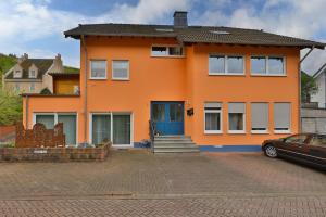 コッヘムにあるFewo Bleserの青い扉と車のオレンジ色の家
