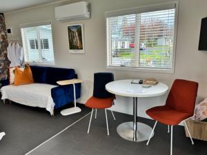 een woonkamer met een bed en een tafel en stoelen bij Okauia Lodge in Matamata