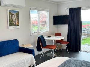 a room with a bed and a table and chairs at Okauia Lodge in Matamata