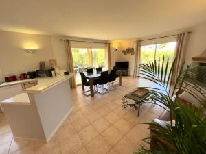 a kitchen and living room with a table and chairs at 72 m2 Centre-ville avec jardin in Porto-Vecchio