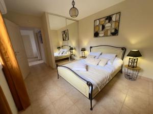a bedroom with a large bed and a mirror at 72 m2 Centre-ville avec jardin in Porto-Vecchio
