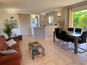 a living room with a dining table and a kitchen at 72 m2 Centre-ville avec jardin in Porto-Vecchio