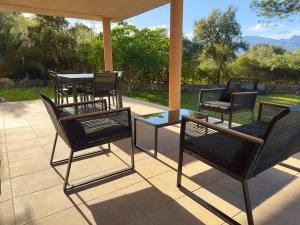 a group of chairs and tables on a patio at 72 m2 Centre-ville avec jardin in Porto-Vecchio +4 photos