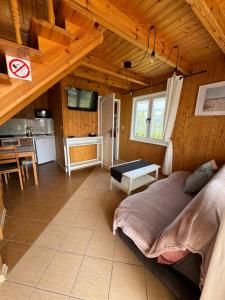 a bedroom with a large bed and a kitchen at Domki wczasowe OSKAR in Chłopy