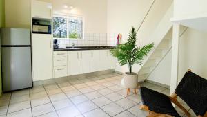 a kitchen with white cabinets and a potted plant at Dream of the Green Flamingo in Willibrordus