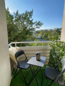 a table and two chairs on a balcony with a coffee mug at Le Sun Valley - Studio Cosy - Free Parking in Montpellier