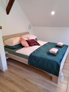 1 dormitorio con 1 cama con manta azul y almohadas en Apartmaji Magda en Zgornje Gorje