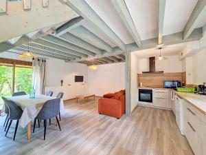 cocina y sala de estar con mesa y sillas en Hameau de Gîtes de St-Victor-en-Marche 