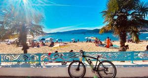 Una bicicleta estacionada junto a una valla en una playa en Apartamento Exclusivo a pie de Playa en Vigo