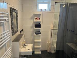 een witte badkamer met een wastafel en een douche bij Bungalow Neuss in Neuss