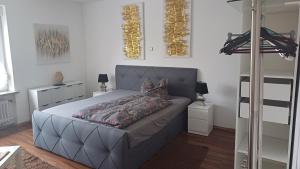 1 dormitorio con 1 cama con cabecero gris en Ferienwohnungen Stadler, en Rödental