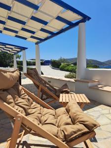 a patio with two chairs and a pergola at Iremia North Kokkali Beach Leros in Gourna