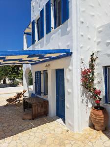 a white building with a blue door and a bench at Iremia North Kokkali Beach Leros in Gourna +31 photos