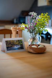 達爾弗頓的住宿－West Hollowcombe Farm，一张桌子上装有鸡蛋和鲜花的花瓶的照片