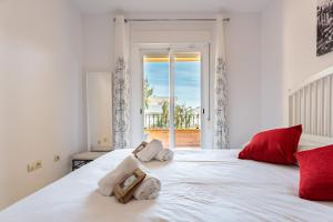een slaapkamer met een groot wit bed met rode kussens bij CT 232 - Eden Golf Sur - Southfacing Apartment in Mijas