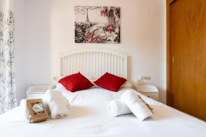 een slaapkamer met een wit bed met rode kussens bij CT 232 - Eden Golf Sur - Southfacing Apartment in Mijas