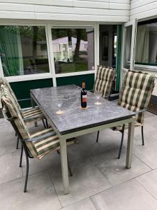 een tafel met 2 stoelen en een fles wijn bij Vakantiehuis ontdek Zuid - Limburg in Simpelveld