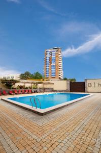 a large swimming pool with a tall building in the background at Bien hotel in Yerevan