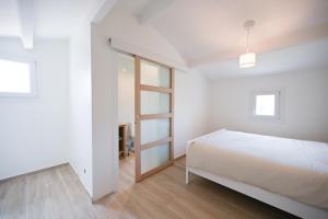 biała sypialnia z łóżkiem i oknem w obiekcie Le Quartz - Grande Maison avec piscine - Tournefeuille w mieście Tournefeuille