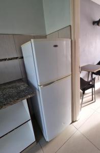 a white refrigerator in a kitchen with a table at Matat Studio Apartments in Matatiele