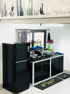 a kitchen with a black refrigerator and a counter at TM Hometay Trung Tâm Phan Thiết in Phan Thiet