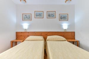 two beds in a bedroom with two lights on the wall at Casa di Chiara Elba in Marciana Marina
