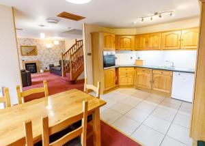 a kitchen and dining room with a wooden table at Courtyard Cottage in Tomich