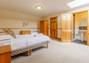 a large bedroom with a bed and a sink at Courtyard Cottage in Tomich