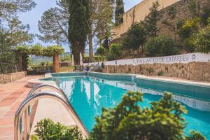 uma piscina ao lado de um edifício com uma placa em Hotel Boutique Palacio De La Duquesa em Ronda