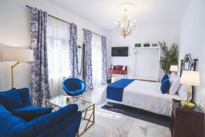 um quarto com uma cama e uma cadeira azul em Hotel Boutique Palacio De La Duquesa em Ronda