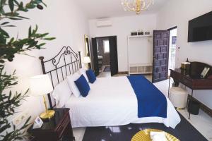 a bedroom with a bed with blue pillows and a desk at Hotel Boutique Palacio De La Duquesa in Ronda +40 photos