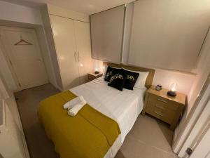 1 dormitorio con 1 cama grande con manta amarilla en CoZZy 1-Bed Apartment in Liverpool St & Shoreditch, en Londres