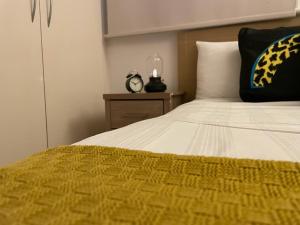 1 dormitorio con 1 cama con reloj en una mesita de noche en CoZZy 1-Bed Apartment in Liverpool St & Shoreditch, en Londres